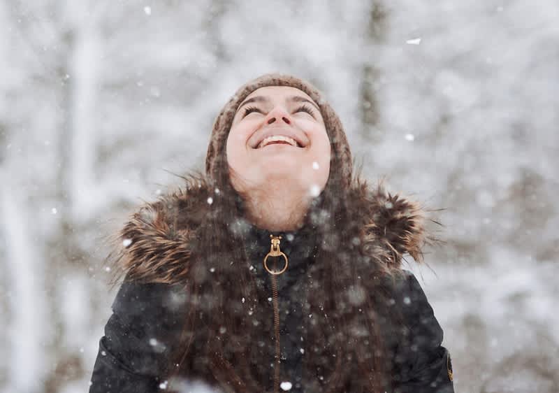 Frau lächelnd in Winterlandschaft