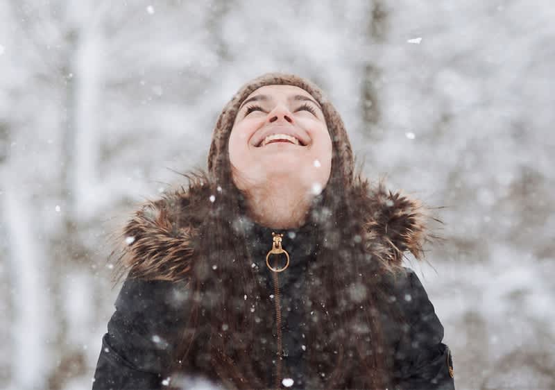 Frau lächelnd in Winterlandschaft