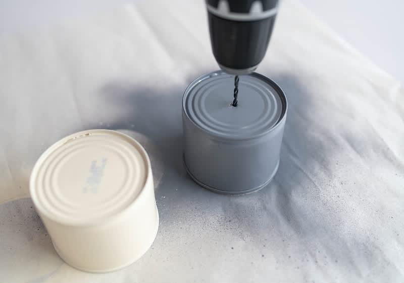 Mit dem Bohrer ein Loch in der Dose machen