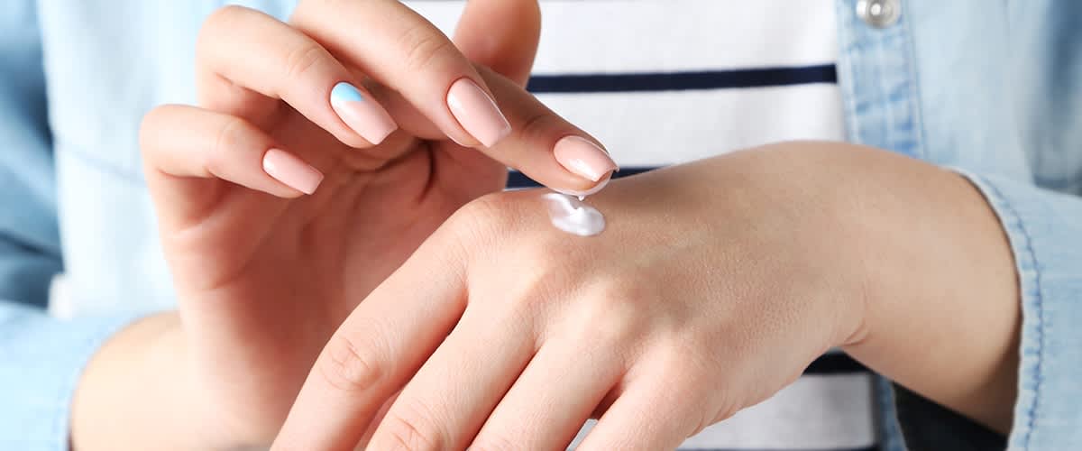 Frauenhände die sich eincremen