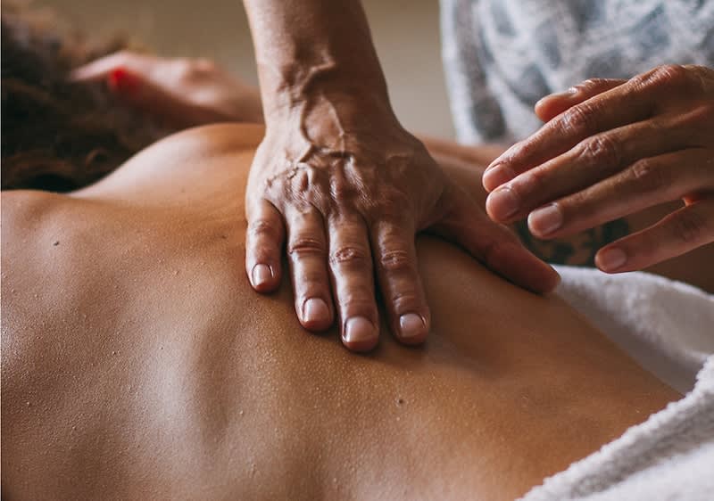 Masaj terapeutic la spate cu mâini care aplică presiune pe piele