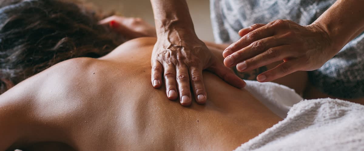 Masaj terapeutic la spate cu mâini care aplică presiune pe piele