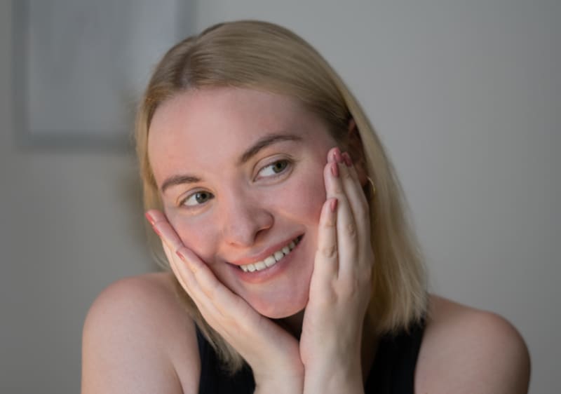 Blonde Frau lächelt beim Gesicht massieren