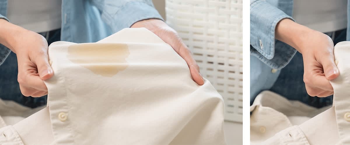 Cămașă albă cu pată de cafea ținută de o mână