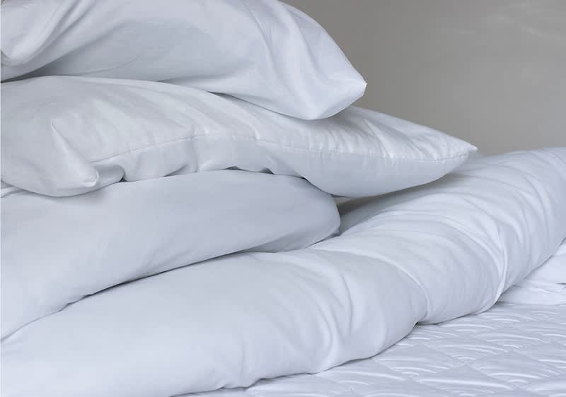 Pernă albă și plapumă albă pe pat