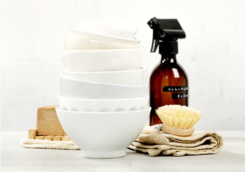 Vase albe stivuite cu perie de curățare și soluție de curățat