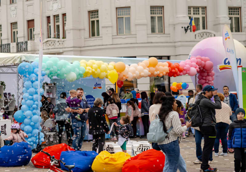 Eveniment în aer liber cu baloane colorate și oameni adunați