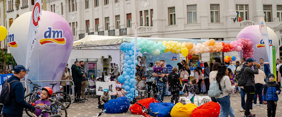 Eveniment în aer liber cu baloane colorate și oameni adunați
