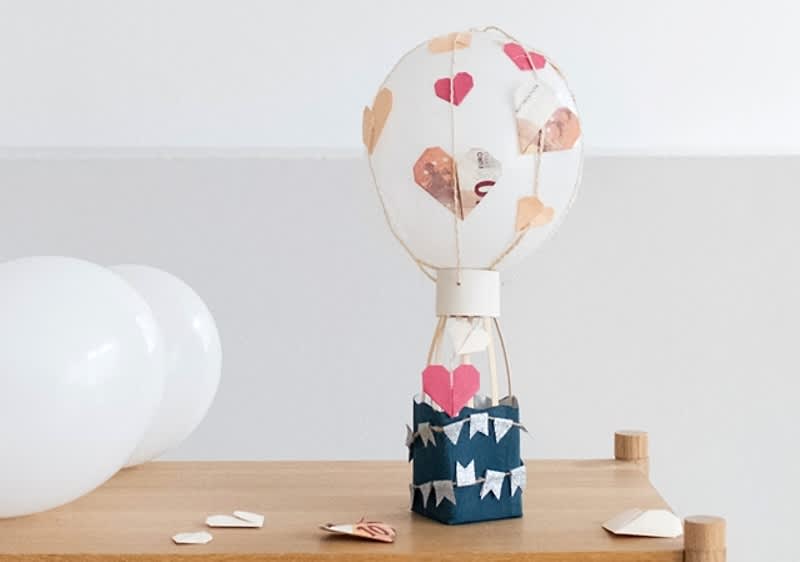 Decor balon cu inimioare într-o cameră luminoasă cu baloane albe pe masă