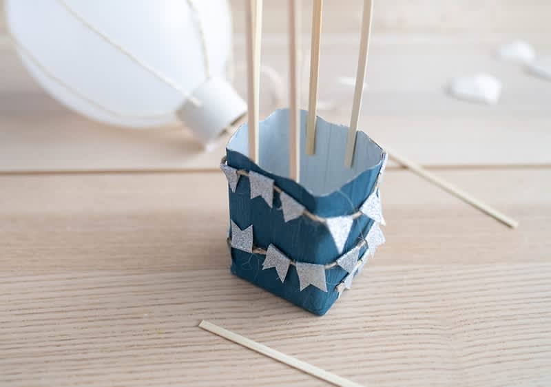 Decorare balon cu steaguri albastre și bețe de lemn pe masă