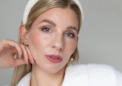 Persoană cu păr blond și bentiță albă în ținută albă de modă