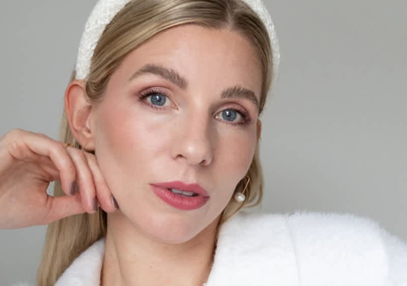 Persoană cu păr blond și bentiță albă în ținută albă de modă