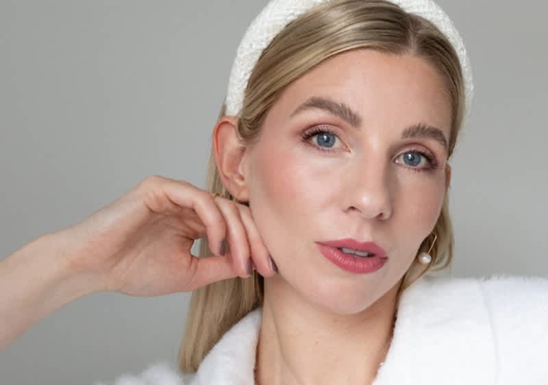 Persoană cu păr blond și bentiță albă în ținută albă de modă