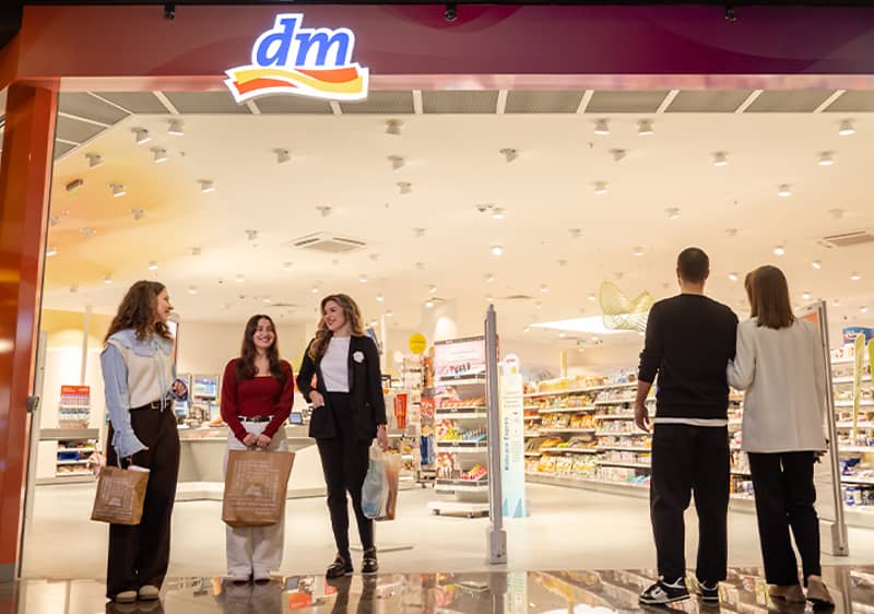 Intrare magazin cu oameni și produse vizibile în interior