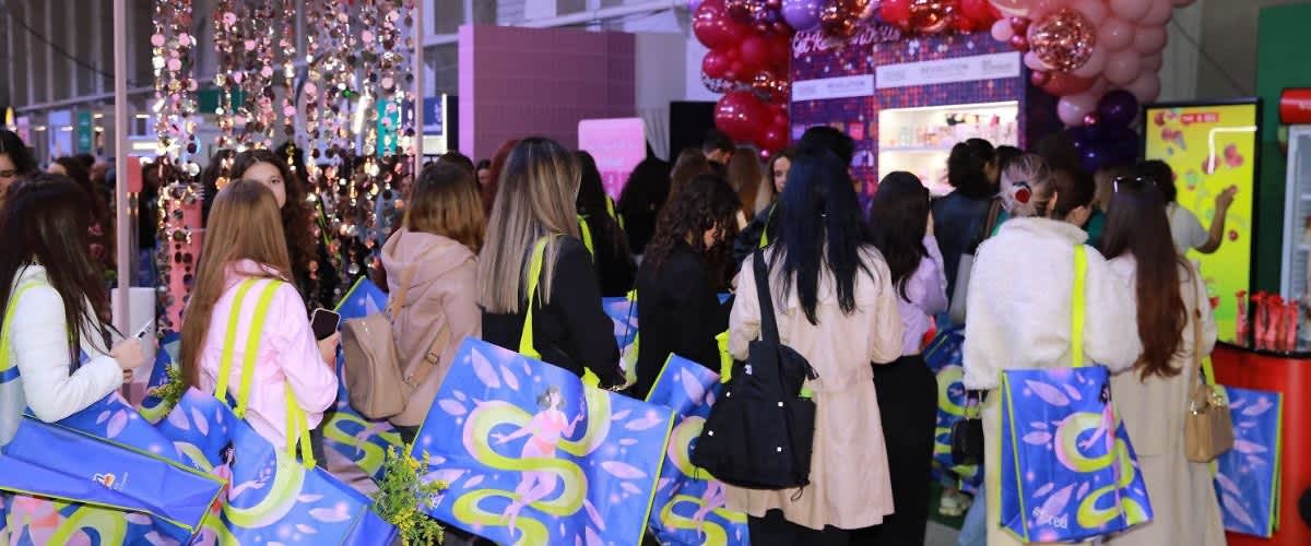 Cuvântul cheie principal: eveniment Grup de persoane la un eveniment cu sacoșe colorate și decor cu baloane