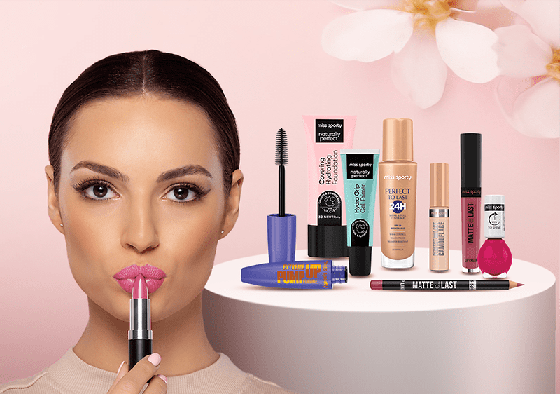 Produse cosmetice diverse pe fundal roz cu flori albe