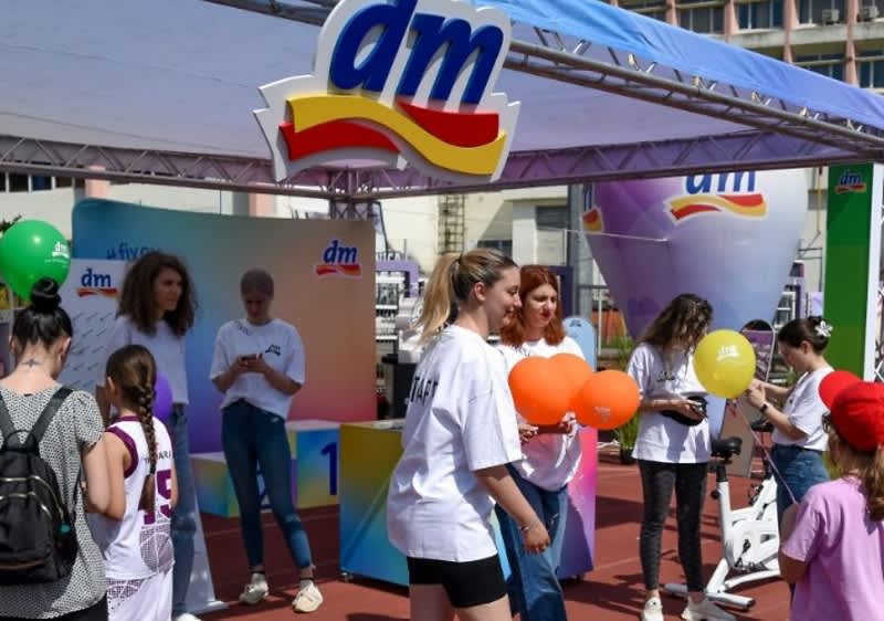 Oameni la un eveniment promoțional DM cu baloane și standuri