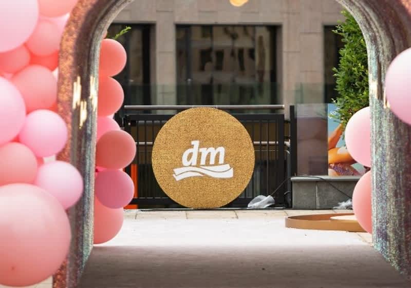 Arcadă decorată cu baloane roz și logo dm pe fundal