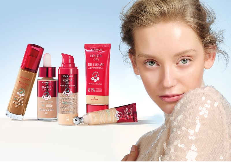 Produse cosmetice Bourjois pe fundal albastru cu față estompată