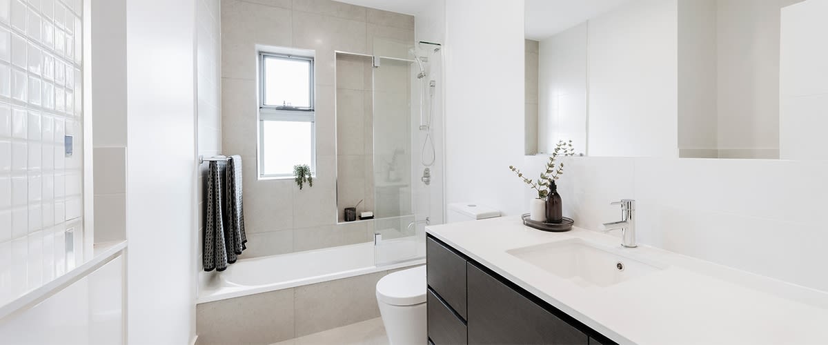 Baie modernă cu cadă, chiuvetă și decor minimalist în nuanțe neutre