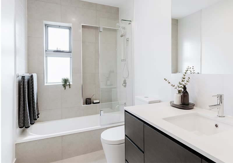 Baie modernă cu cadă, chiuvetă și decor minimalist alb și gri