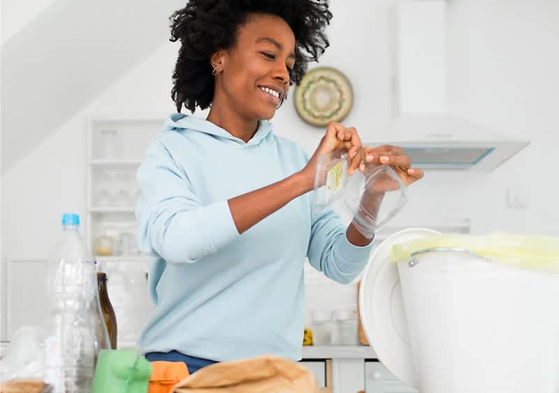 Cuvântul cheie principal: reciclare Persoană sortând deșeuri pentru reciclare în bucătărie