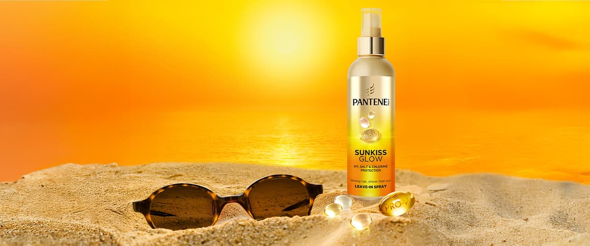 Protecție solară Pantene pe plajă cu ochelari de soare și mare în fundal