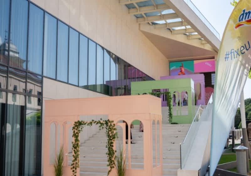expoziție Expoziție colorată pe scări exterioare cu structuri pastelate și banner DM