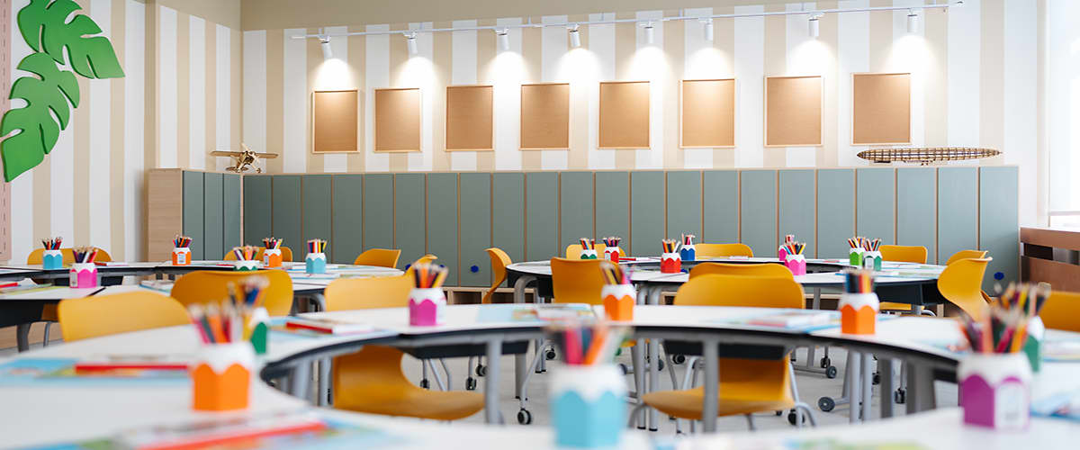 Sala de clasă modernă cu mese rotunde și scaune galbene