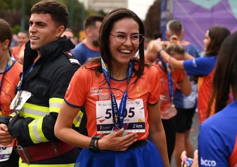 Cuvântul cheie principal: maraton Participanți la maraton purtând medalii și tricouri portocalii