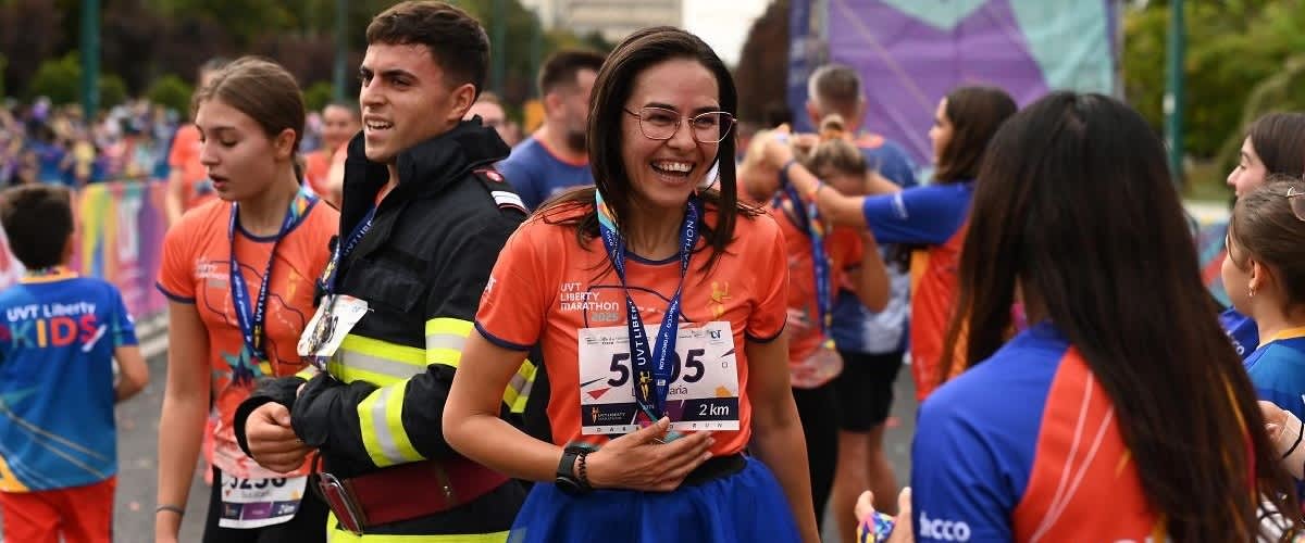 Cuvântul cheie principal: maraton Participanți la maraton purtând medalii și tricouri portocalii