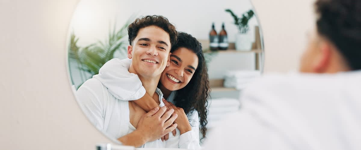 Cuvântul cheie principal: cuplu Imagine: Cuplu îmbrățișat reflectat în oglindă cu plante și sticle în fundal