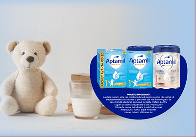 Ursuleț de pluș lângă lapte praf Aptamil și pahar cu lapte