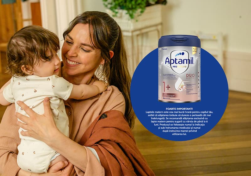 Cutie de lapte praf Aptamil și mamă ținând bebeluș în brațe