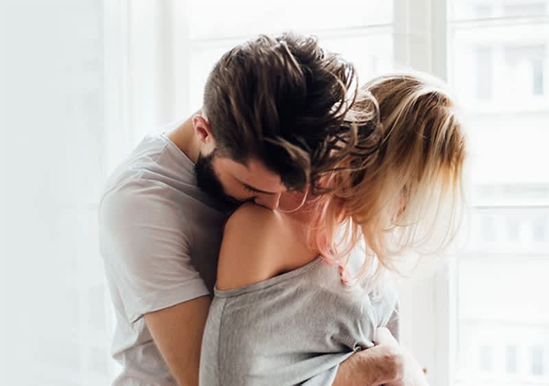 Cuplu îmbrățișat într-o cameră luminoasă