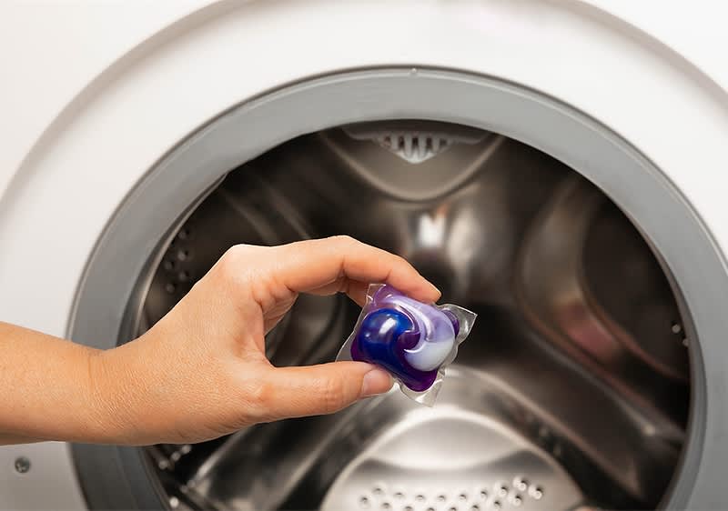 Capsulă de detergent lângă mașină de spălat