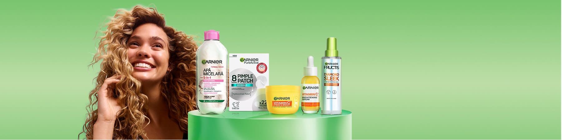 Produse cosmetice Garnier pe fundal verde aranjate pe un piedestal санитар