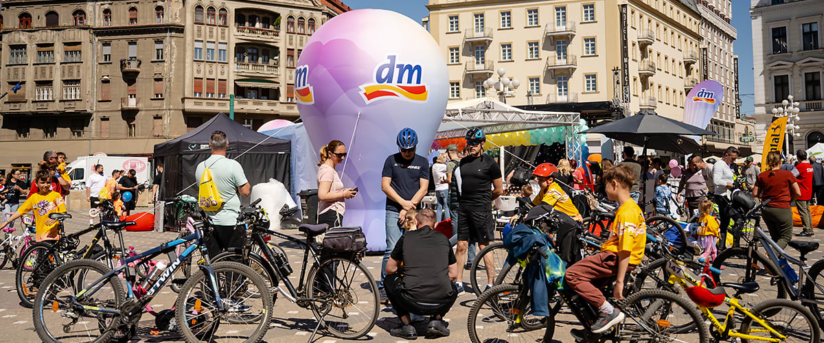 Eveniment ciclism în piață cu biciclete participanți și balon promoțional dm