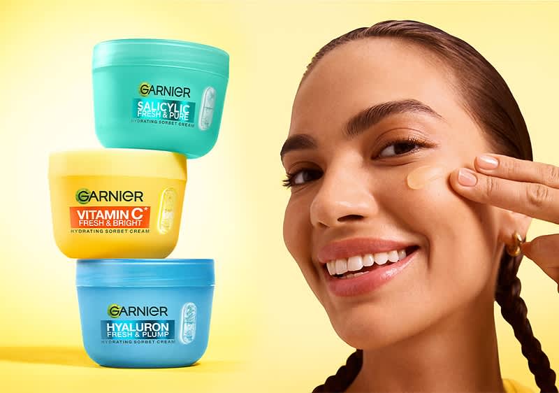 Cremă Garnier stivuite pe fundal galben lângă chip de femeie cu păr împletit