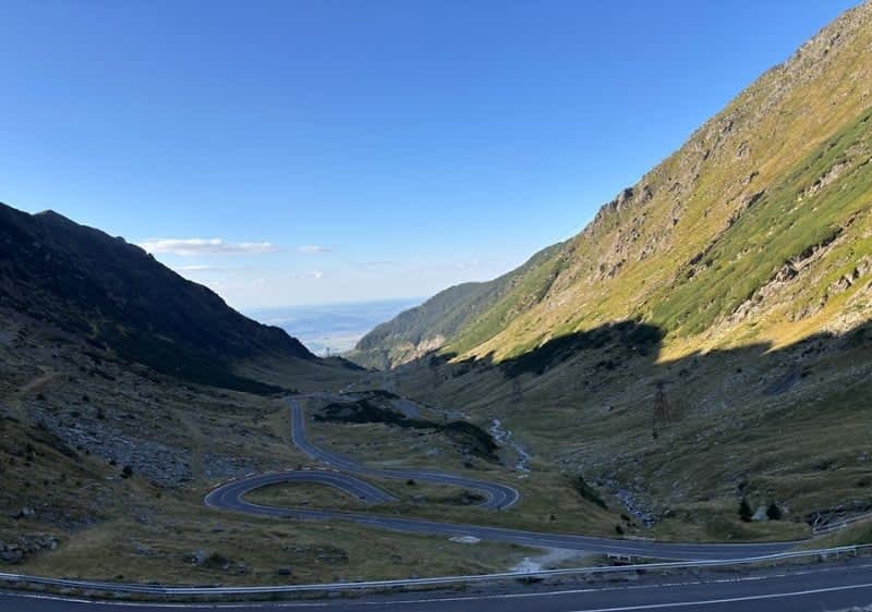 Transfăgărășan serpentină de munte cu vale verde și cer senin