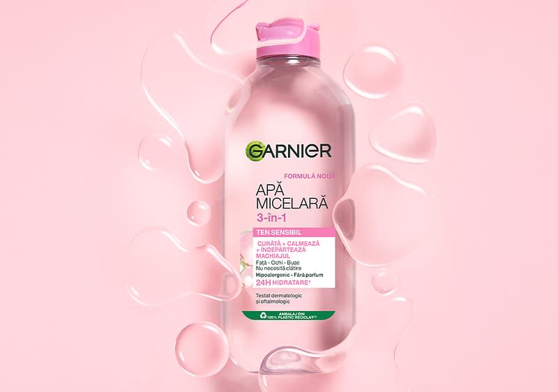 Apă micelară Garnier 3-în-1 pentru ten sensibil pe fundal roz cu picături de apă