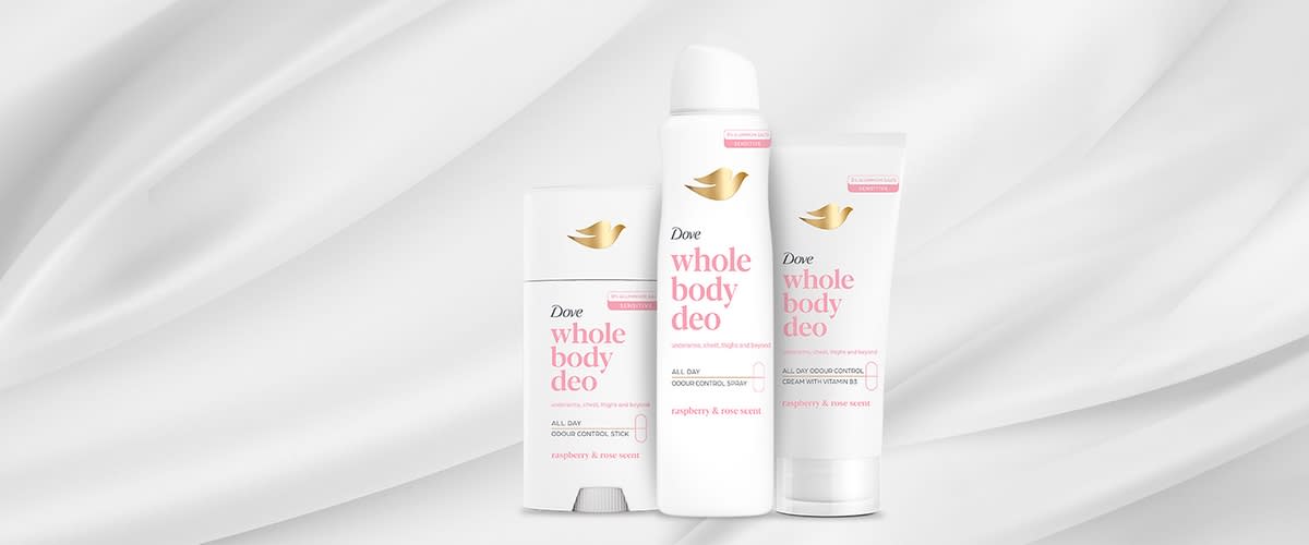 Dove whole body deo set deodorant spray stick și cremă pe fundal gri cu accente roz