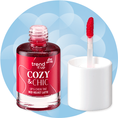 Červený lesk na pery a líca s aplikátorom na modrom pozadí