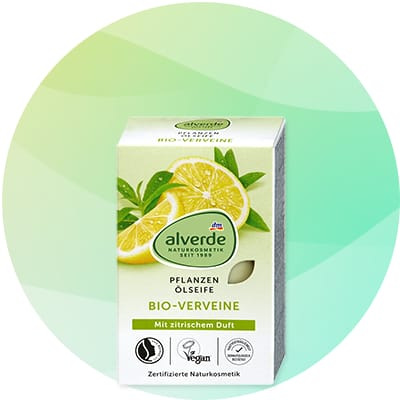 Balenie rastlinného oleja Alverde s obrázkom dvoch nakrojených citrónov a zelených listov, nápisy „alverde NATURKOSMETIK seit 1988“, „PFLANZEN ÖLE/SITE“, „BIO-VERVEINE“ a „Mit zitrischem Duft“, ikony certifikátov a text „Zertifizierte Naturkosmetik“