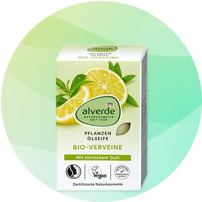 Balenie rastlinného oleja Alverde s obrázkom dvoch nakrojených citrónov a zelených listov, nápisy „alverde NATURKOSMETIK seit 1988“, „PFLANZEN ÖLE/SITE“, „BIO-VERVEINE“ a „Mit zitrischem Duft“, ikony certifikátov a text „Zertifizierte Naturkosmetik“
