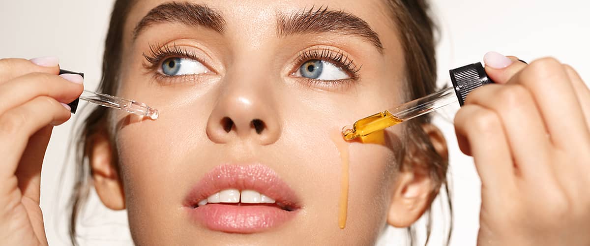 Žena si nanáša kvapkadlom vitamín C na pleť