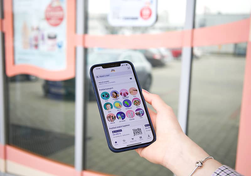 Ruka s mobilom s aplikáciou Moja dm-App