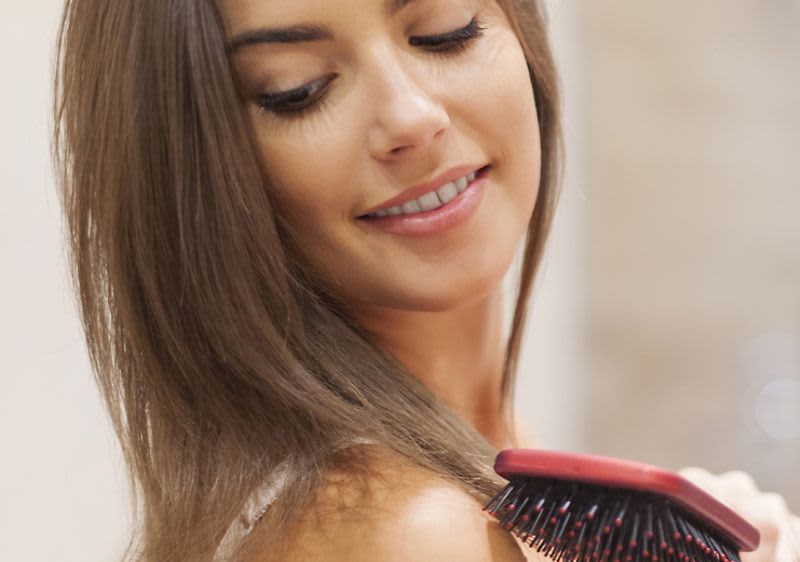 žena s kefou pri zrkadle