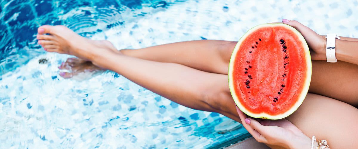 ženské nohy  pri bazéne s melónom