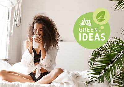 žena na posteli so šálkou v ruke a logo green ideas